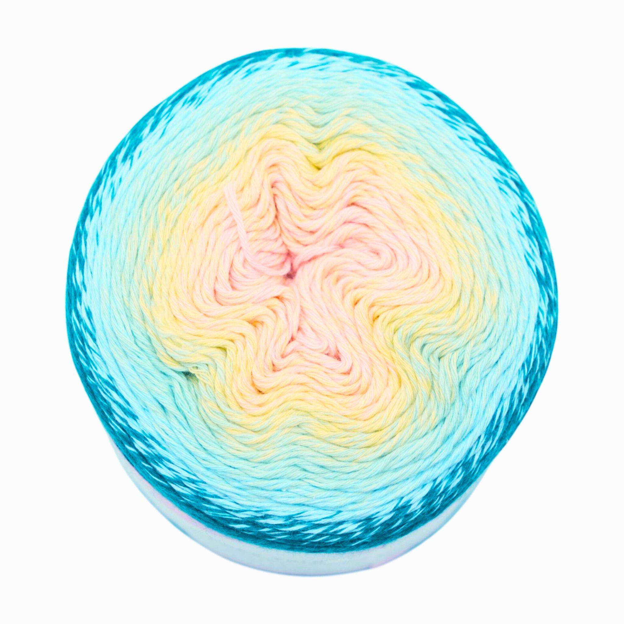 Multicolored yarn ball with a gradient from blue to pink on a white background