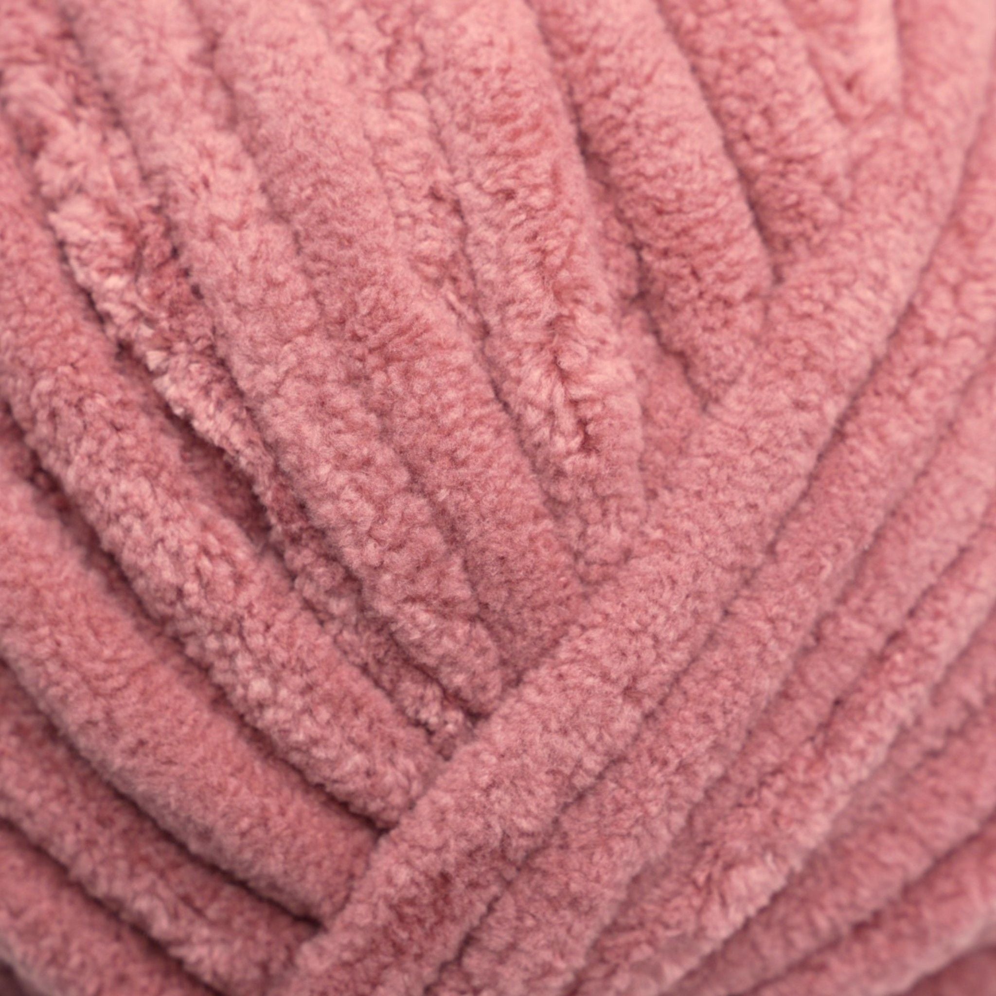A skein of Okey Dokeys brand Jumbo Velvet Chenille Yarn in pink color.
