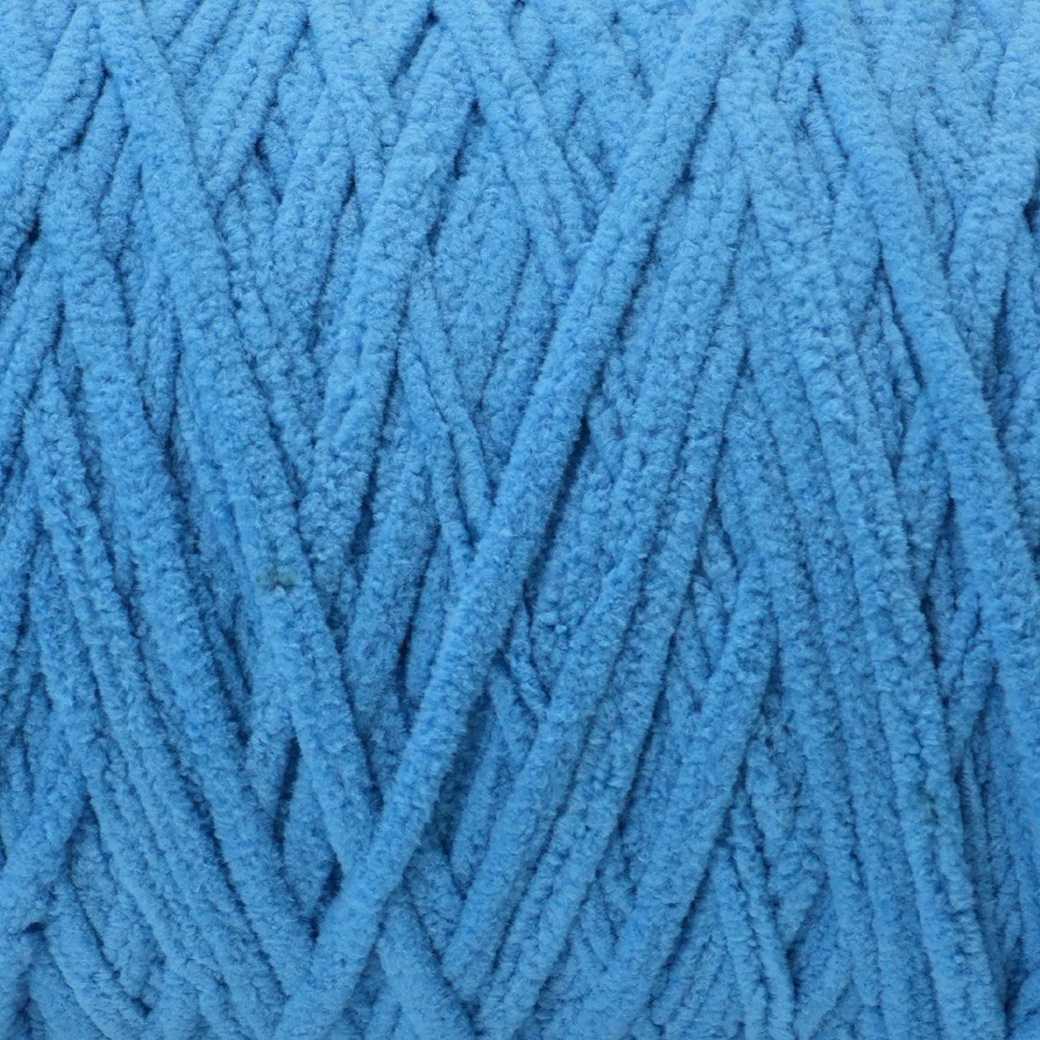 close up of blue Okey Dokey brand chenille yarn with labels showing the yarn type and brand name.