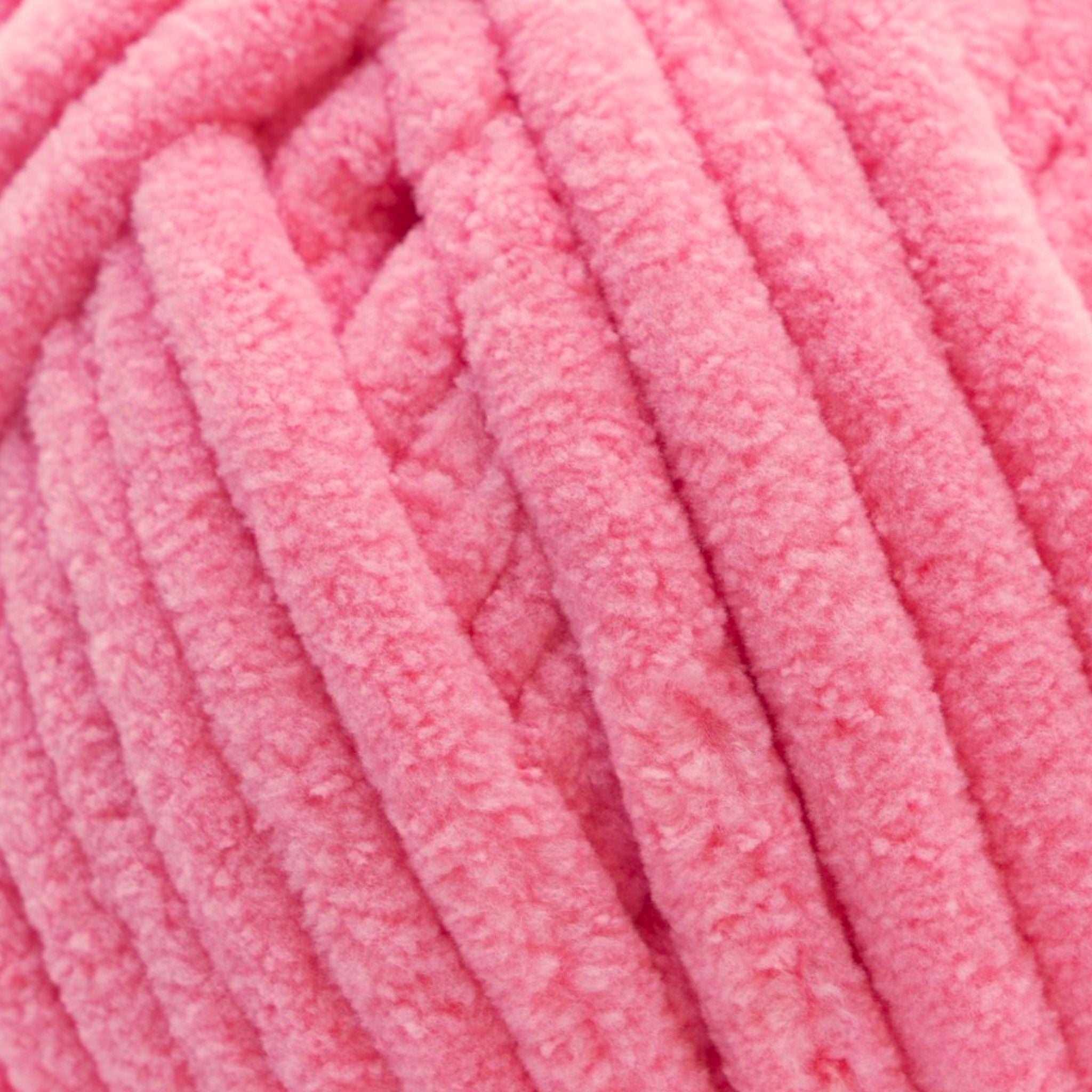 A skein of Okey Dokeys brand Jumbo Velvet Chenille Yarn in pink color up close to show the soft texture