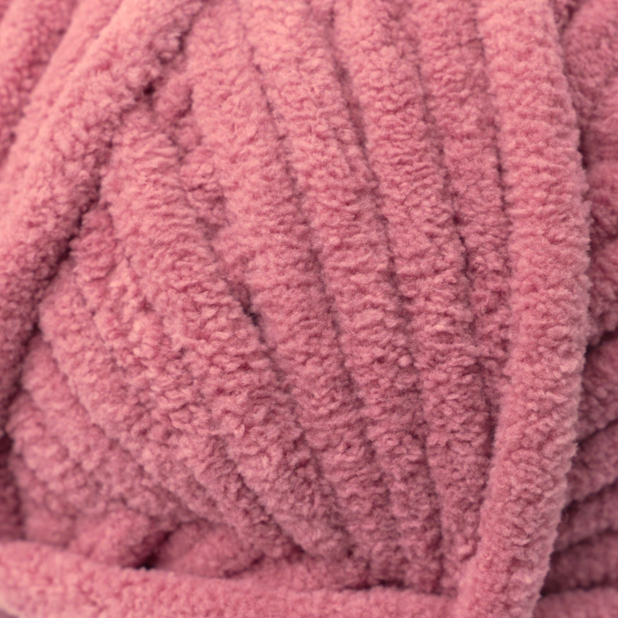 A skein of Okey Dokeys brand Jumbo Velvet Chenille Yarn in pink color.