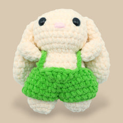 A crochet bunny kit with yarn in yellow and pink, a crochet hook, safety eyes, a stuffing needle, stitch markers, scissors, and a pattern booklet, all presented with a 'Okey Dokey' branded box.