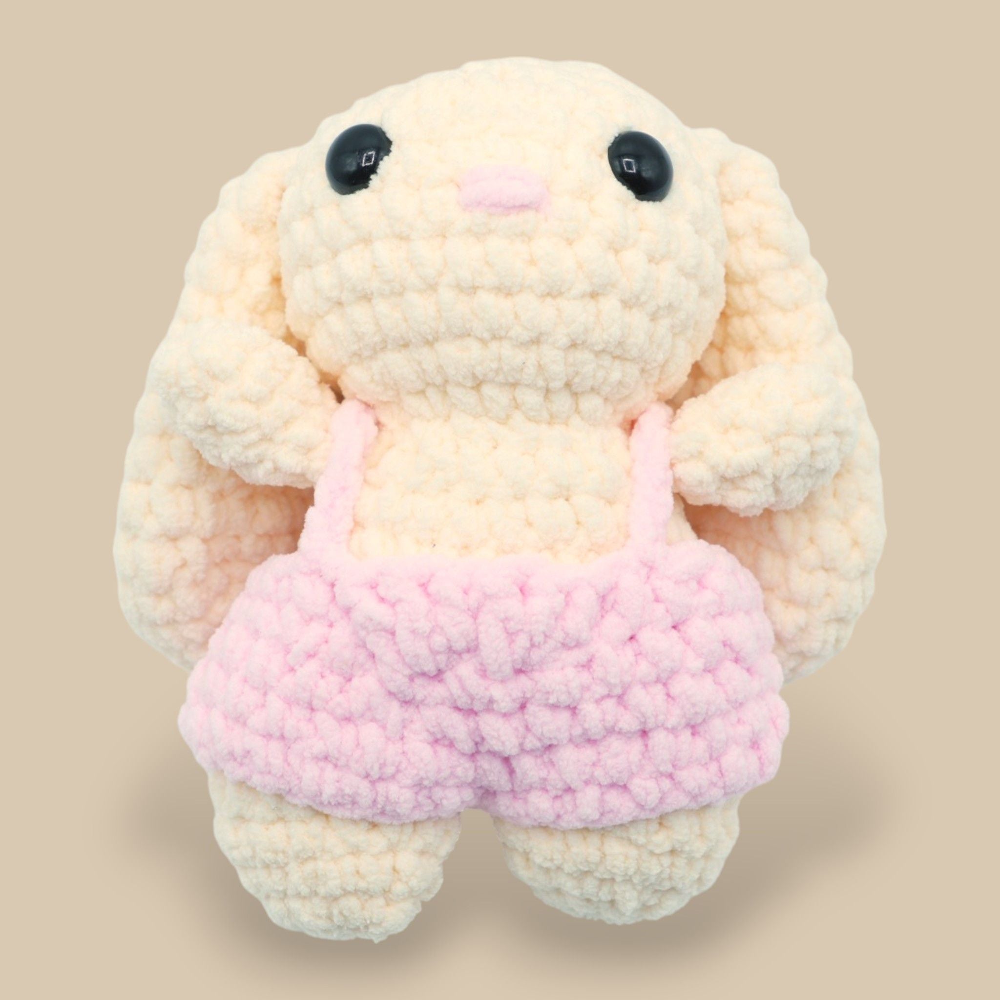 A crochet bunny kit with yarn in yellow and pink, a crochet hook, safety eyes, a stuffing needle, stitch markers, scissors, and a pattern booklet, all presented with a 'Okey Dokey' branded box.