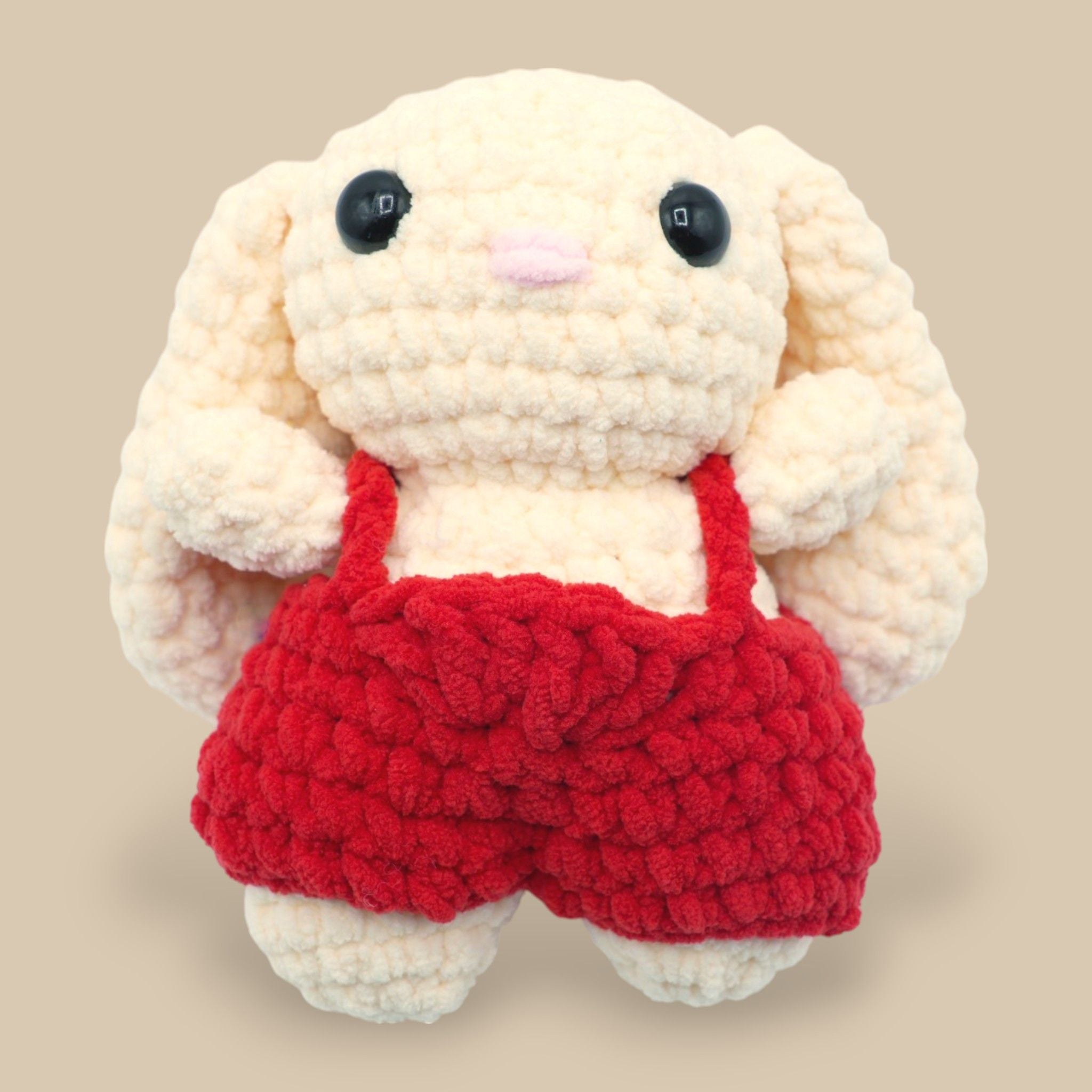 A crochet bunny kit with yarn in yellow and pink, a crochet hook, safety eyes, a stuffing needle, stitch markers, scissors, and a pattern booklet, all presented with a 'Okey Dokey' branded box.