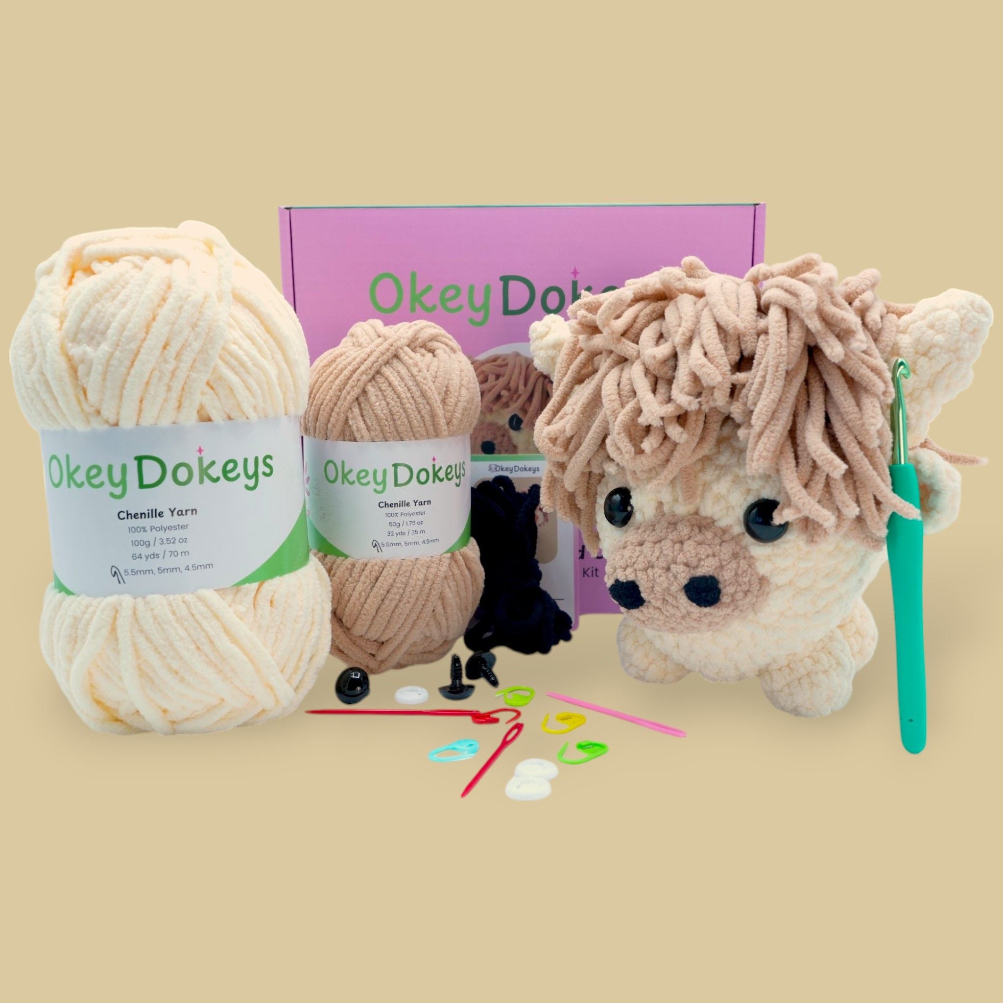 A crochet Highland Cow Kit by OkeyDokey, featuring yarn in beige and brown colors, a crochet hook, safety eyes, stuffing needle, stitch markers, and the finished product displayed as a plush Highland Cow.