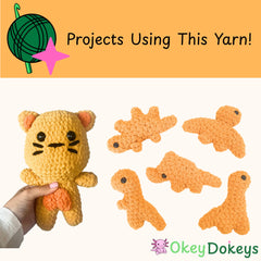 Hand holding a crocheted cat toy with other crocheted toys on a white background, featuring 'Okey Dokeys' brand. made with bulky chenille yarn