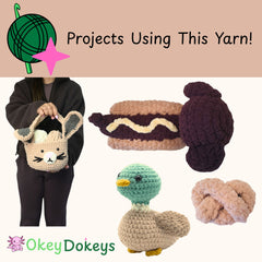 Person holding a cat-shaped basket with crocheted items including a hot dog, bun, and other toys on a beige background.