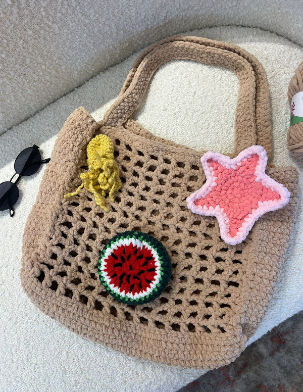 Crocheted bag with colorful patches on a textured surface
