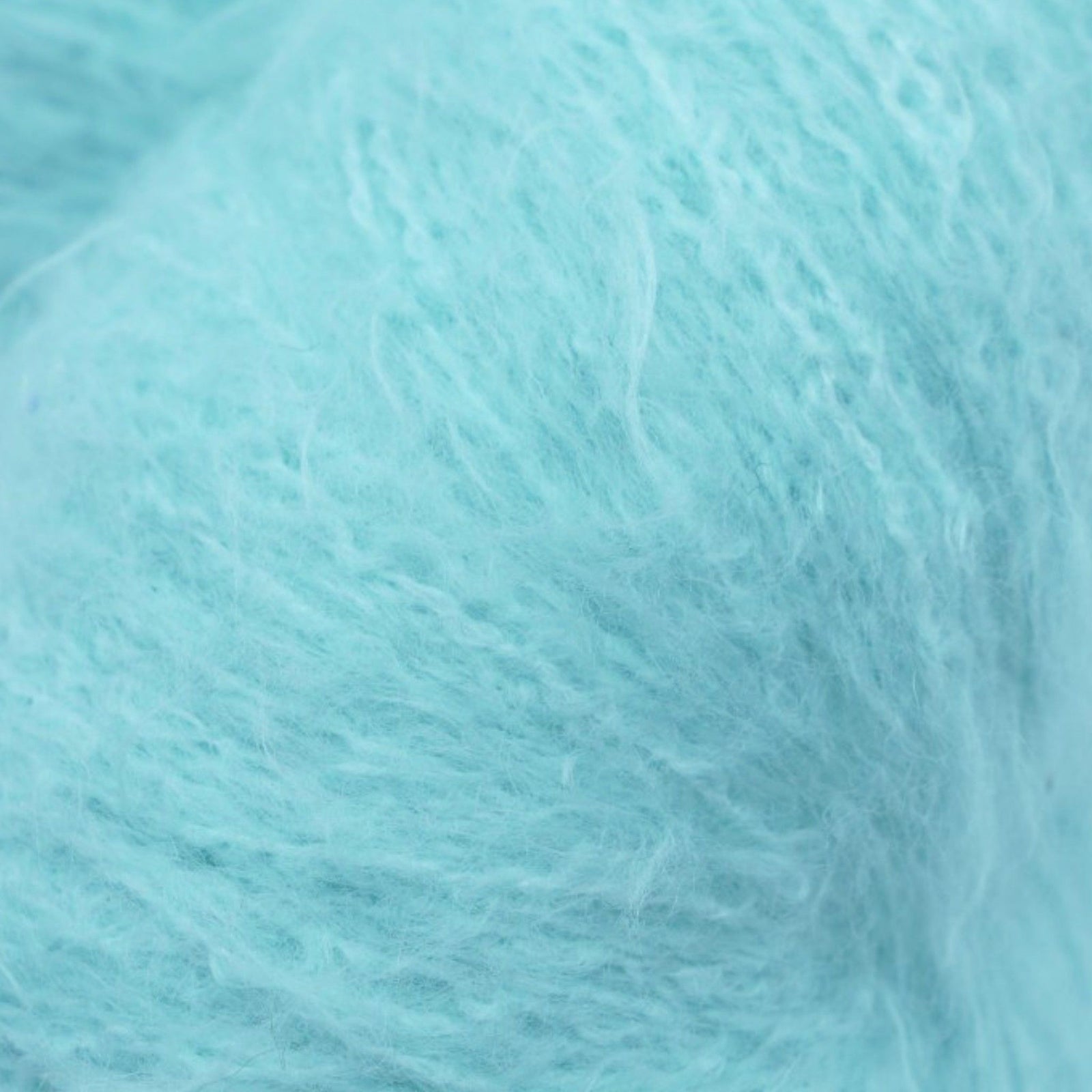 A skein of fuzzy lace yarn in a light blue color, displayed against a plain background.