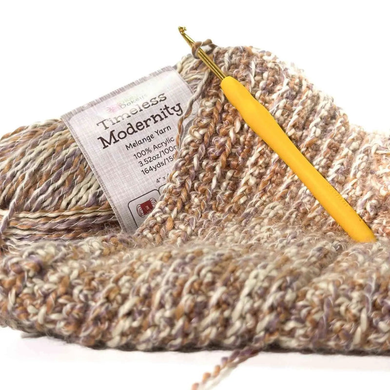 Ball of yarn with a yellow crochet hook and label on a white background
