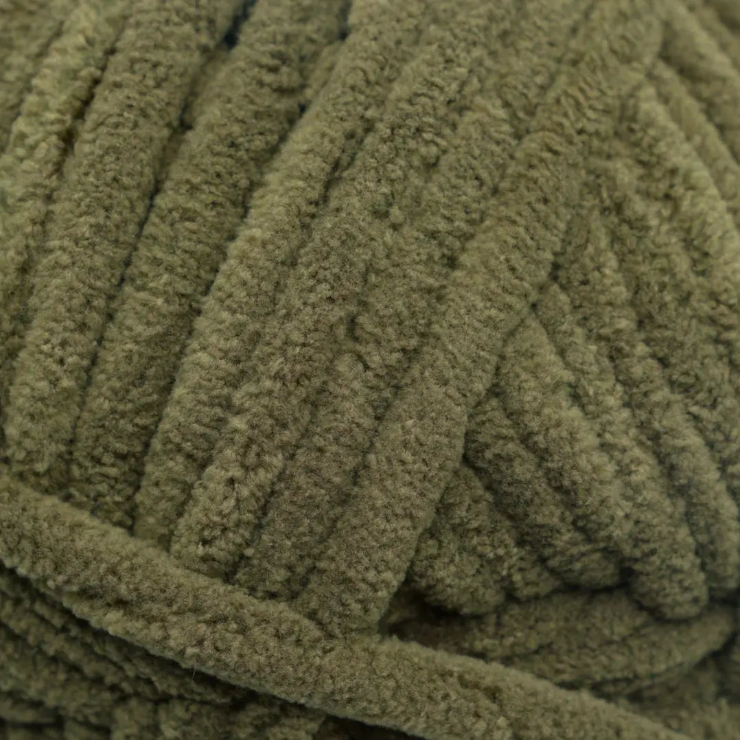 Close-up of a ball of green yarn on a white background