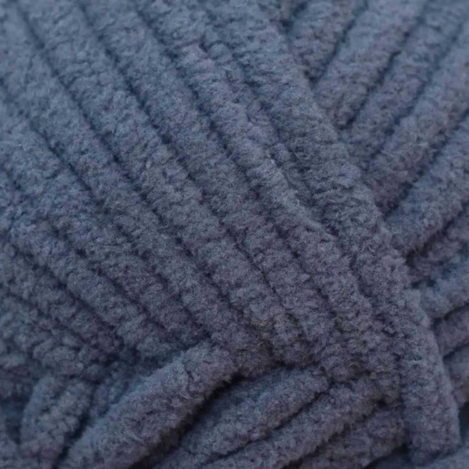 Close-up of a blue textured fabric with a knitted pattern