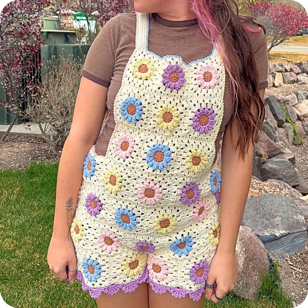 Person wearing a colorful crochet apron outdoors.