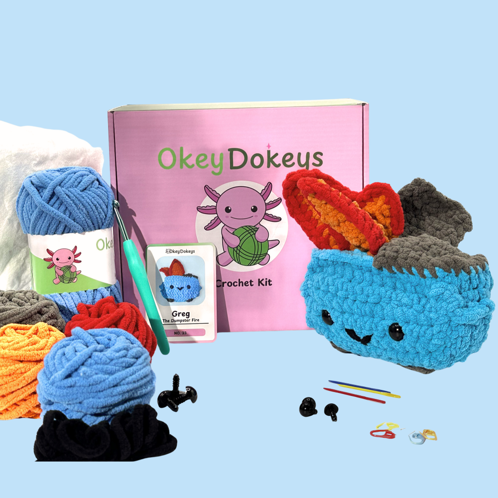 Crochet kit with yarn, hooks, and a small crocheted creature on a light blue background.