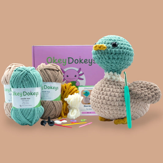 A crochet kit to create a duck amigurumi plush, including yarn in various colors, a crochet hook, safety eyes, and a pattern guide.