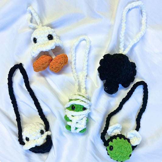Collection of crochet car hangers for Halloween on a white blanket
