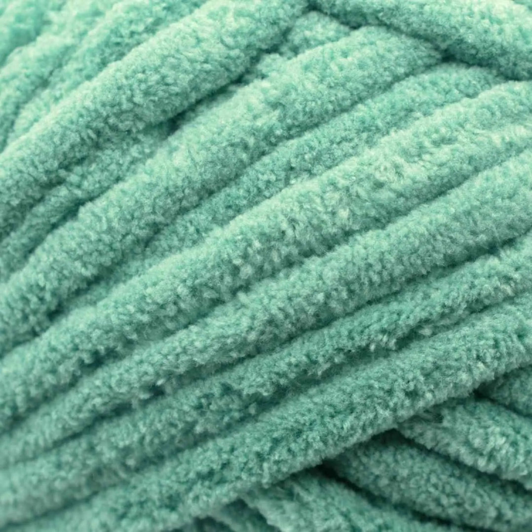 Close-up of teal yarn with a textured surface