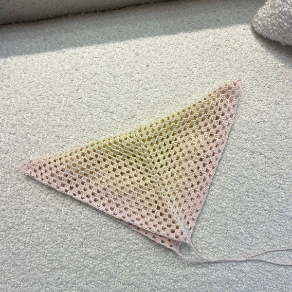 Triangular piece of mesh fabric on a textured surface