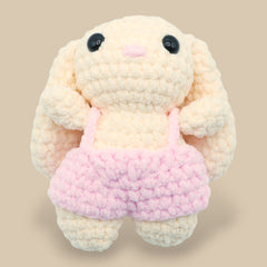 A crochet bunny kit with yarn in yellow and pink, a crochet hook, safety eyes, a stuffing needle, stitch markers, scissors, and a pattern booklet, all presented with a 'Okey Dokey' branded box.