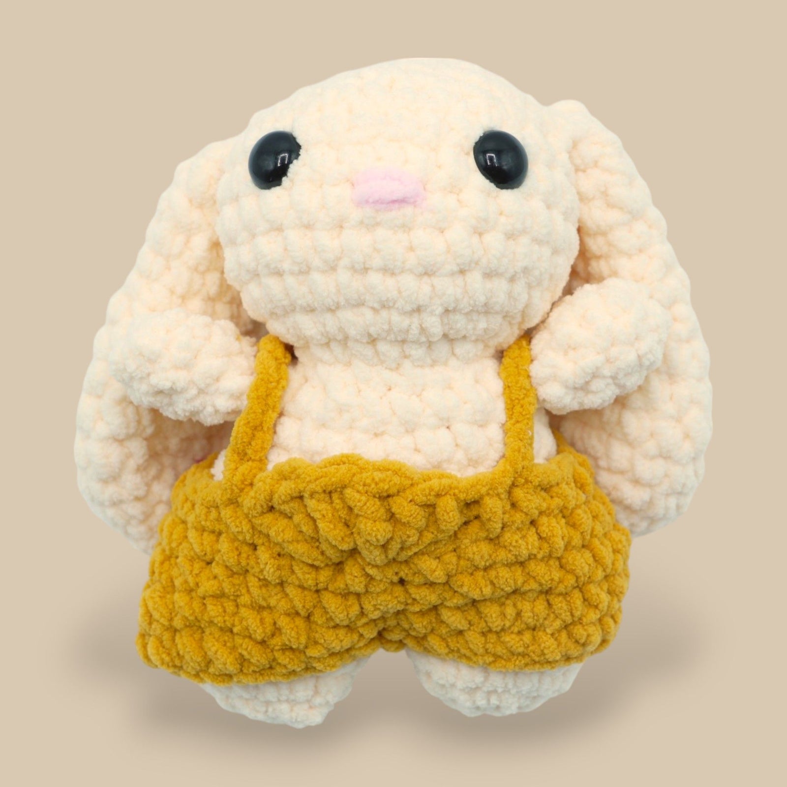 A crochet bunny kit with yarn in yellow and pink, a crochet hook, safety eyes, a stuffing needle, stitch markers, scissors, and a pattern booklet, all presented with a 'Okey Dokey' branded box.
