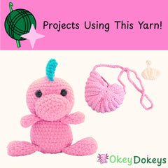 Pink crochet toy with blue hair and a pink yarn ball on a pink background with 'Okey Dokeys' branding.